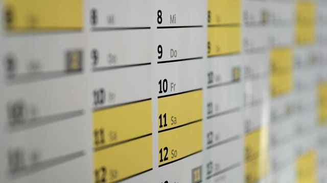 A wall calendar with some days highlighted.
