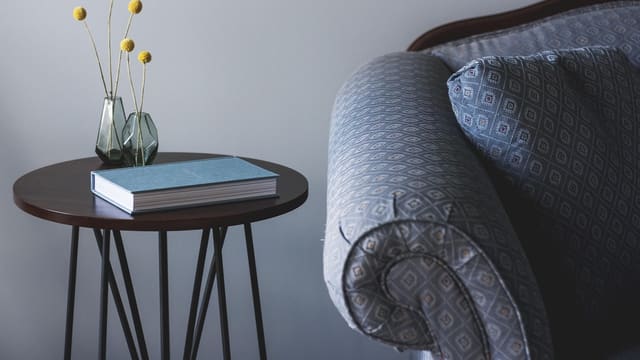 A quiet corner with an armchair, a small table and a book.